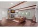 Cozy living room showcasing a stone fireplace and wood beams, and hardwood flooring at 109 Walking Horse Trl, Davidson, NC 28036