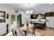 Cozy dining area with a wooden table, stylish chandelier, and sliding doors to the outdoor patio at 112 Aspire Cir, Wingate, NC 28174