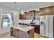 Well-lit kitchen featuring granite counters, stainless steel appliances and dark wood cabinets and island at 112 Aspire Cir, Wingate, NC 28174