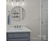 Well-lit bathroom featuring a large, round mirror, modern fixtures, and a stylish blue vanity at 113 Ervin St, Belmont, NC 28012