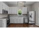 Bright kitchen featuring white cabinets, stainless steel appliances, and modern lighting at 113 Ervin St, Belmont, NC 28012