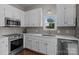 Well-lit kitchen with white cabinets, stainless steel appliances, and a gray tile backsplash at 113 Ervin St, Belmont, NC 28012