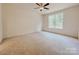 A bright bedroom showcases neutral carpet, a ceiling fan, and a window offering natural light at 118 3Rd Nw Ave, Conover, NC 28613