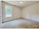 Cozy bedroom featuring neutral carpet and trim with a window providing natural light at 118 3Rd Nw Ave, Conover, NC 28613