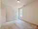 A carpeted bedroom with a double closet and a window is well-lit by an overhead light at 118 3Rd Nw Ave, Conover, NC 28613
