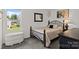 Comfortable bedroom featuring a dark metal bed frame, plush carpet, and a window view at 1207 Skyflower Way, Charlotte, NC 28214