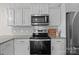 This kitchen has white cabinets, granite countertops, stainless steel appliances, and gray subway tile backsplash at 1207 Skyflower Way, Charlotte, NC 28214