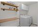 Functional laundry room with modern appliances, upper cabinets, and wooden shelving at 1207 Skyflower Way, Charlotte, NC 28214