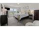 Bright main bedroom showcasing a metal bed frame, plush carpet, and a double-hung window at 1207 Skyflower Way, Charlotte, NC 28214