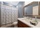 Neutral bathroom with modern vanity, decorative mirror, and patterned shower curtain at 12644 Lahinch Ct, Charlotte, NC 28277