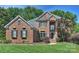Stunning brick home featuring lush landscaping, a manicured lawn, and charming architectural details at 12644 Lahinch Ct, Charlotte, NC 28277