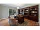 Office with custom wood built-ins, large window and hardwood floors at 12644 Lahinch Ct, Charlotte, NC 28277