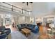 Spacious living room with a large blue sofa and hardwood floors, next to an open concept kitchen at 12644 Lahinch Ct, Charlotte, NC 28277