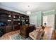 Spacious office with custom wood shelving and trim, hardwood floors, and elegant furnishings at 12644 Lahinch Ct, Charlotte, NC 28277