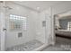 Bright bathroom with tiled walk-in shower featuring white tiles, glass block window, and pebble floor at 12644 Lahinch Ct, Charlotte, NC 28277