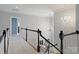 Bright foyer with hardwood staircase featuring black painted railings, white carpet, and chandeliers at 12644 Lahinch Ct, Charlotte, NC 28277