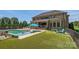 Expansive backyard featuring a pristine pool, lush lawn, and inviting outdoor seating area at 14041 Mccord Rd, Huntersville, NC 28078