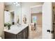 Bright bathroom with marble countertop, dark cabinets, and open doorway to the bedroom at 14041 Mccord Rd, Huntersville, NC 28078