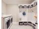 Bright laundry room with modern washer and dryer, custom storage and tile floor at 14041 Mccord Rd, Huntersville, NC 28078
