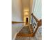 Carpeted staircase with wood railing leads to the lower level at 14608 Waterside Dr, Charlotte, NC 28278