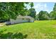 A well-maintained backyard with lush green grass and mature trees surrounding the property at 14821 Cumberland Dr, Charlotte, NC 28227