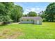 A well-maintained backyard with lush green grass and mature trees surrounding the property at 14821 Cumberland Dr, Charlotte, NC 28227