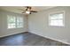 Spacious bedroom with laminate flooring, ceiling fan, and two bright windows at 14821 Cumberland Dr, Charlotte, NC 28227