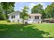 Well-maintained home exterior with mature tree, showcasing a tidy front lawn at 14821 Cumberland Dr, Charlotte, NC 28227