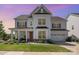 Traditional two-story home features a covered front porch, manicured landscaping, and a two-car garage at 15103 Keyes Meadow Way, Huntersville, NC 28078