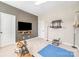 Home gym featuring a flat screen TV, rowing machine, blue workout mat, and ceiling fan at 15103 Keyes Meadow Way, Huntersville, NC 28078