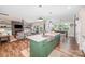 Open concept kitchen with a green island, stainless sink, and view into the living and dining areas at 15103 Keyes Meadow Way, Huntersville, NC 28078