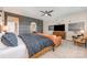 Comfortable primary bedroom with a stylish bed, couch, flat screen TV and interesting wall decor at 15103 Keyes Meadow Way, Huntersville, NC 28078