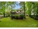 Expansive backyard featuring a screened porch and deck, surrounded by lush greenery and mature trees, offering a private outdoor space at 17433 Glassfield Dr, Huntersville, NC 28078