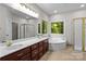Bathroom featuring a double vanity, a whirlpool tub, and natural light at 17433 Glassfield Dr, Huntersville, NC 28078