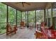 Relaxing screened porch furnished with wooden chairs and a tile floor for outdoor enjoyment at 17433 Glassfield Dr, Huntersville, NC 28078