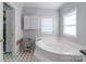 Bright bathroom with a large corner tub and storage cabinets at 1909 Mountain Springs Church Rd, Monroe, NC 28112