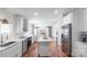 Open kitchen featuring white cabinets, stainless steel appliances, subway tile backsplash and hardwood floors at 1909 Mountain Springs Church Rd, Monroe, NC 28112