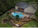 Aerial view of a backyard with a beautiful pool, patio, outdoor kitchen, and landscaped gardens at 1912 Dawnhurst Ln, York, SC 29745