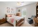 Cozy bedroom with a wooden bed frame, ceiling fan, and a comfortable chair near the window at 1912 Dawnhurst Ln, York, SC 29745