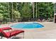 Backyard pool with lounge chairs and black fence for privacy, surrounded by mature trees at 1912 Dawnhurst Ln, York, SC 29745