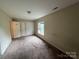 Cozy carpeted bedroom with a window offering natural light and functional closet space at 2012 Ashley Rd, Charlotte, NC 28208