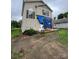 Damaged two-story home featuring a front porch, siding, and windows covered with a blue tarp at 2012 Ashley Rd, Charlotte, NC 28208