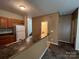 This kitchen features brown cabinets and white appliances, with a breakfast bar overlooking the living area at 2012 Ashley Rd, Charlotte, NC 28208