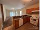 Open kitchen featuring wood cabinets, a view to a carpeted living room, and white appliances at 2012 Ashley Rd, Charlotte, NC 28208