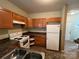 Classic kitchen featuring wood cabinets, white appliances, and neutral countertops at 2012 Ashley Rd, Charlotte, NC 28208