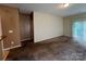 Spacious carpeted living room with a sliding glass door and neutral colored walls at 2012 Ashley Rd, Charlotte, NC 28208