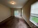 Carpeted living room with a sliding glass door, windows with blinds, and neutral wall color at 2012 Ashley Rd, Charlotte, NC 28208