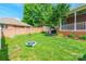 Backyard featuring a covered porch, brick retaining wall, and a mini trampoline for recreation at 2079 Audubon Dr, Rock Hill, SC 29732