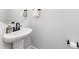 Well lit half bathroom featuring a pedestal sink, decorative mirror, and modern fixtures at 223 S Bruns Ave, Charlotte, NC 28208