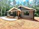 Charming home with a covered porch, wood door, and black trim surrounded by trees at 2330 Neill Rd, Lancaster, SC 29720